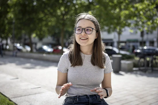 Eine junge Frau gestikuliert mit den Händen.