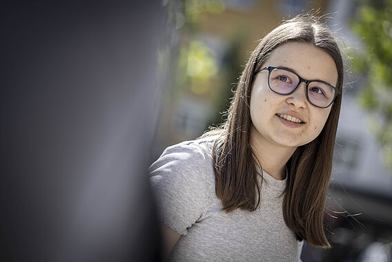 Eine junge Frau blickt in die Kamera.